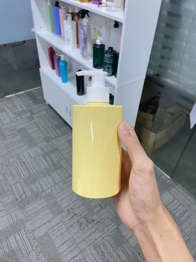Chai nhựa vòi bơm màu vàng pastel cầm trên tay tại kho mẫu